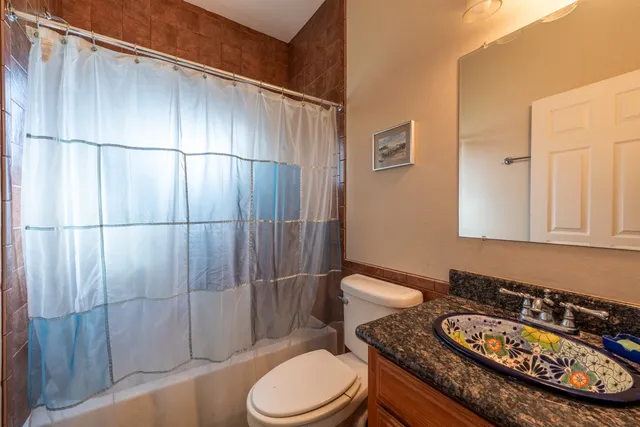 a bathroom with a granite countertop toilet sink and shower