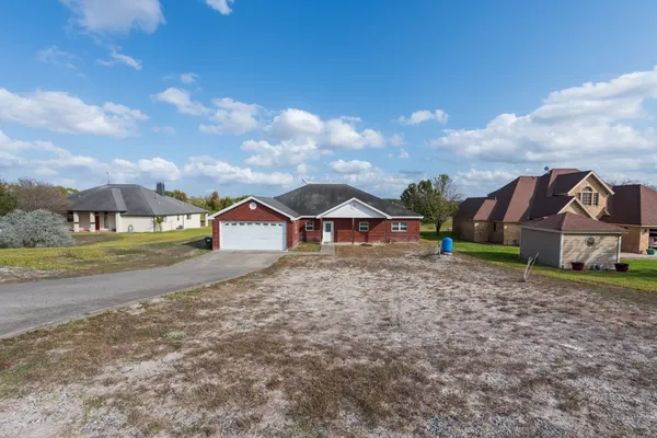 a view of a house with a yard and large tree