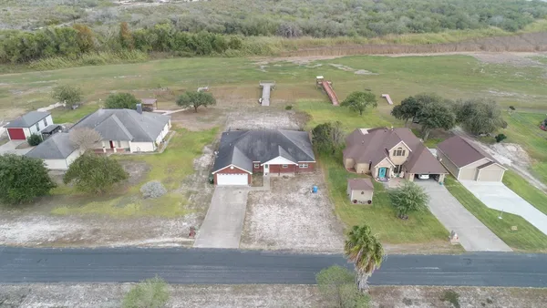 an aerial view of residential houses with outdoor space and river