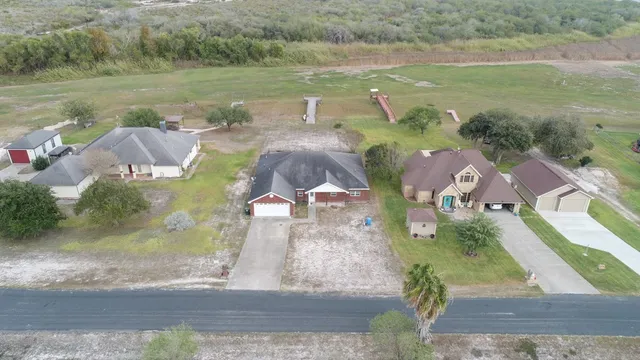 an aerial view of residential houses with outdoor space and river