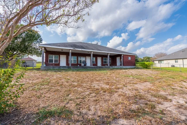 a front view of a house with yard and green space