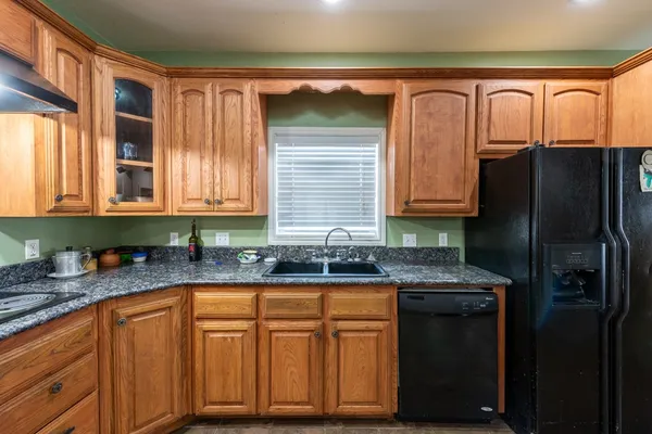 a kitchen with granite countertop stainless steel appliances a sink and refrigerator