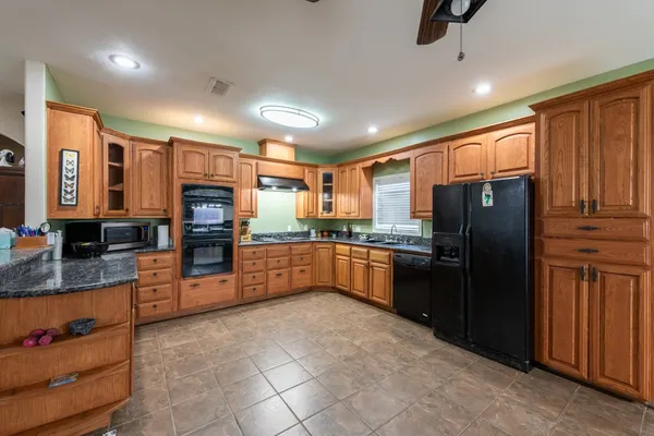 a kitchen with stainless steel appliances granite countertop a refrigerator and a stove