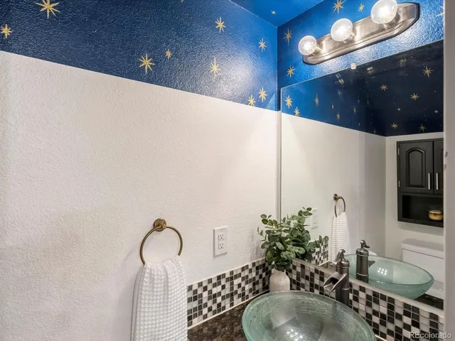 a bathroom with a sink a light fixture and a mirror