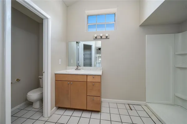 a spacious bathroom with a toilet a sink and mirror