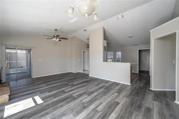a view of a room with a kitchen and wooden floor
