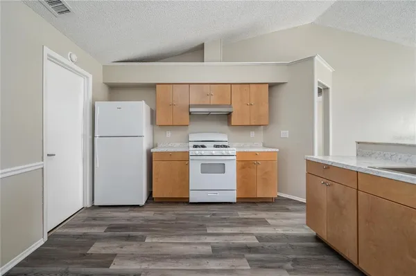 a kitchen with a stove a refrigerator and a sink