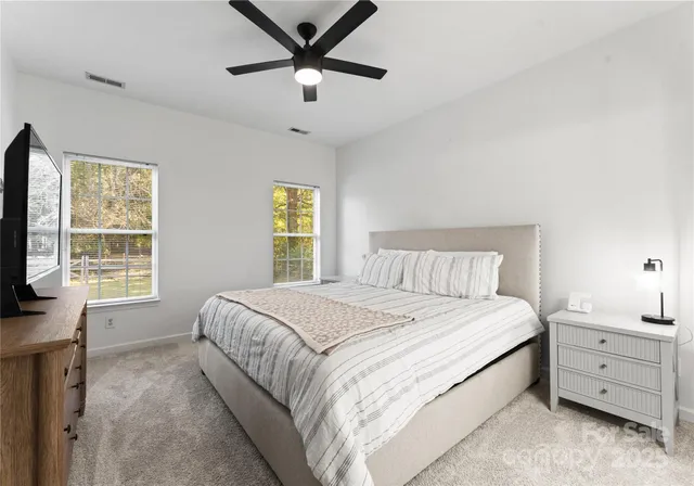 a spacious bedroom with a large bed and a flat screen tv