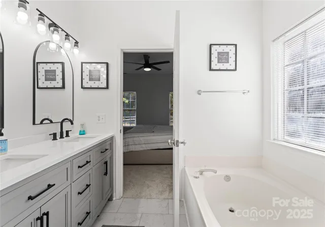 a bathroom with a tub sink and mirror
