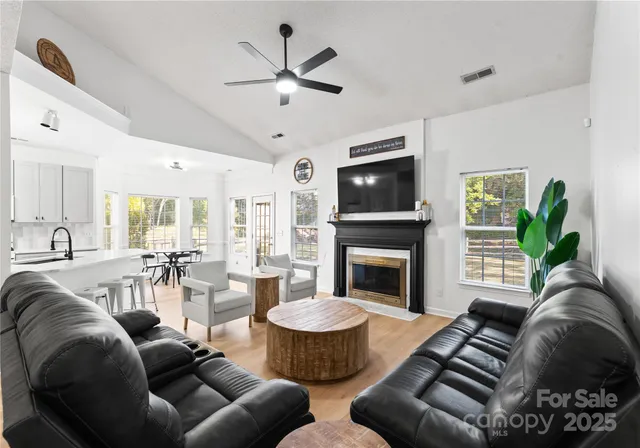 a living room with furniture a fireplace and a flat screen tv