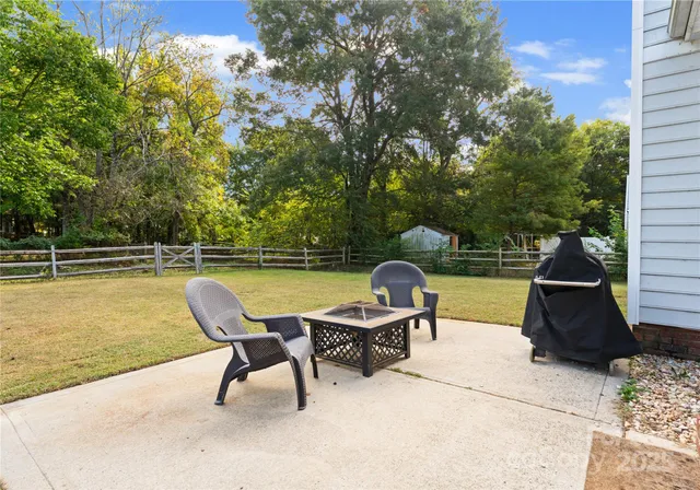 a view of a swimming pool with chairs and a yard