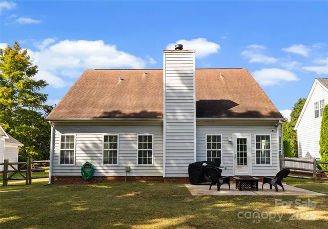 a front view of a house with a garden and trees