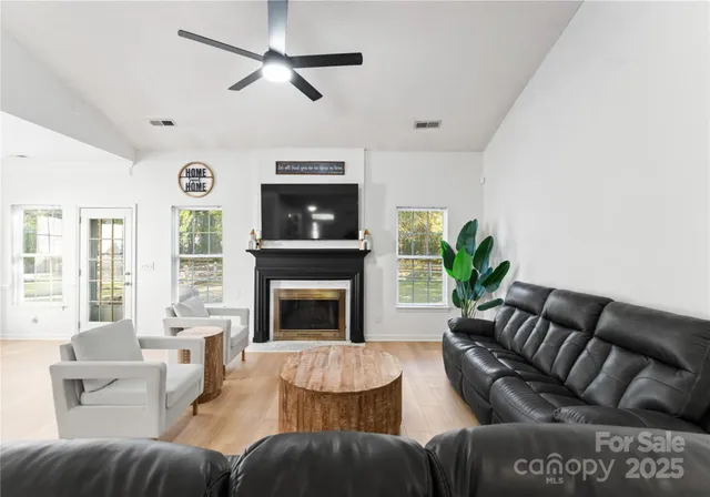 a living room with furniture a large window and a fireplace