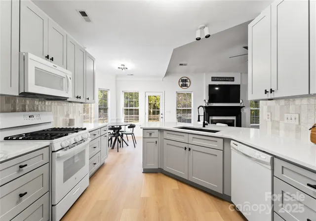 a large kitchen with stainless steel appliances granite countertop a stove sink and cabinets