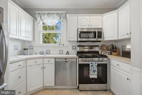 a kitchen with cabinets appliances and a window