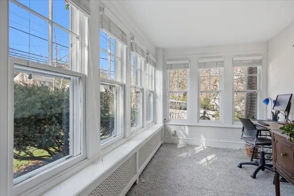 a view of a room with a large window and wooden floor