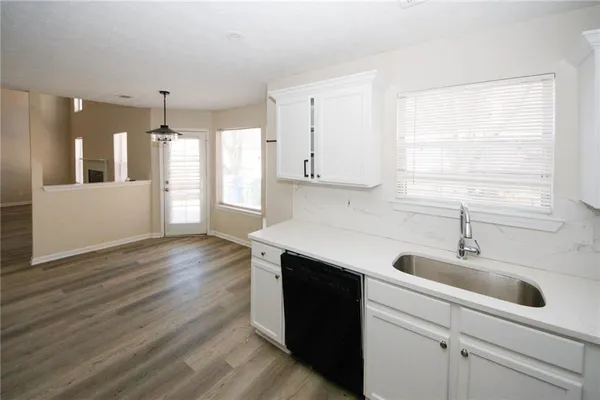 a kitchen with a sink cabinets and wooden floor