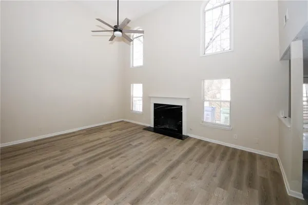 an empty room with windows and a fireplace