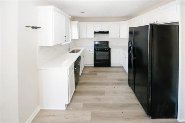 a kitchen with a refrigerator and a sink