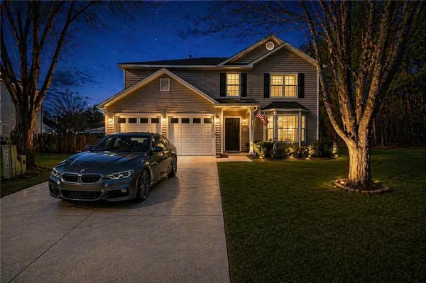 a car parked in front of a house with a small yard