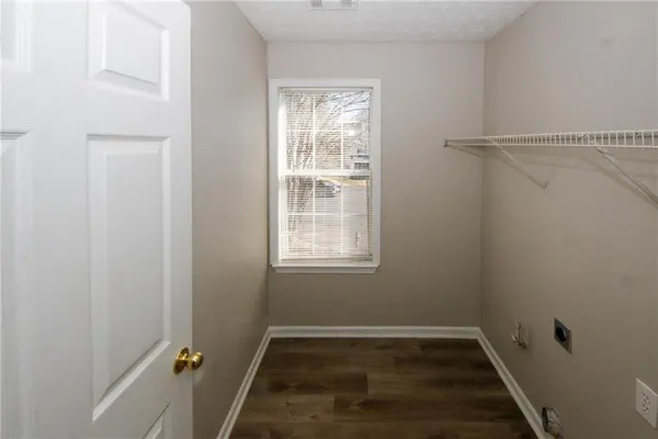 an empty room with wooden floor windows and entrance
