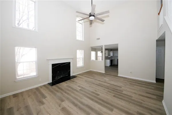 a view of empty room with a fireplace and wooden floor