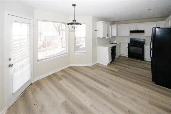 a view of a kitchen with a stove cabinets and wooden floor