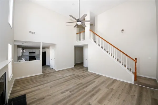 a view of a hallway with wooden floor and staircase