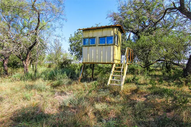 a yellow house with trees in the background