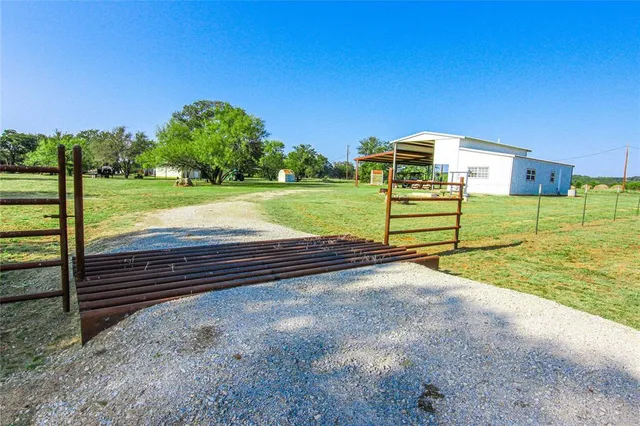 a view of a yard with wooden fence