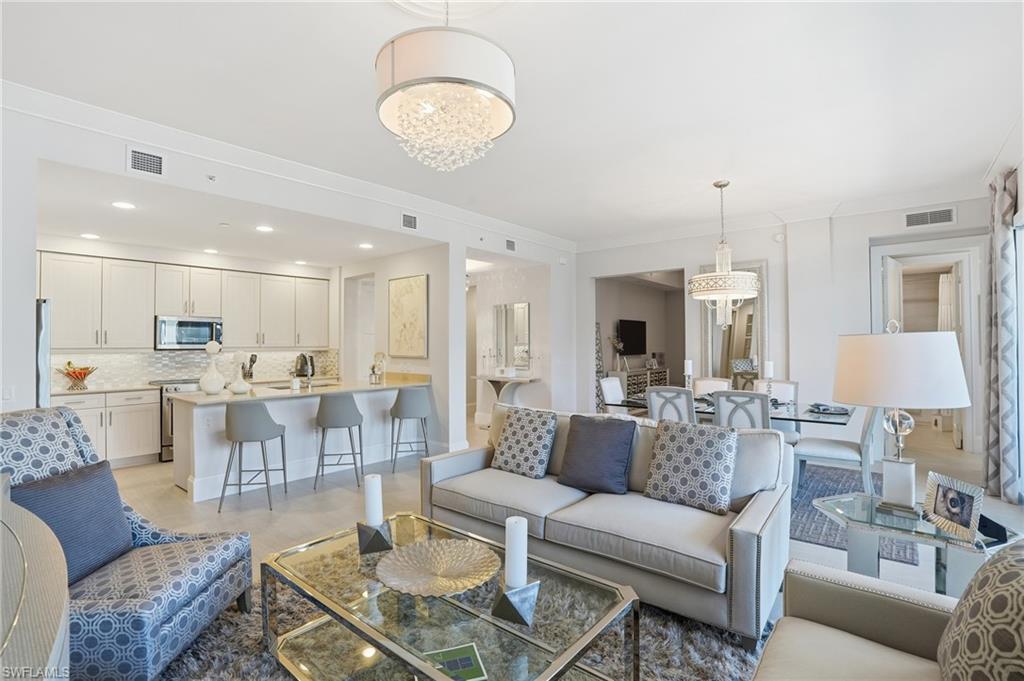 a living room with furniture kitchen and a chandelier