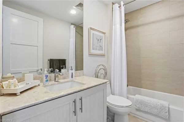 a bathroom with a sink a mirror and a shower curtain