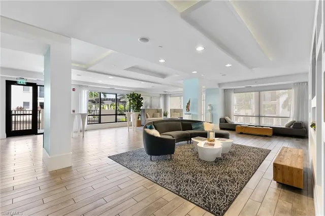 a view of a dining room and livingroom with furniture wooden floor a chandelier