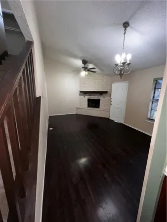 an empty room with wooden floor and staircase
