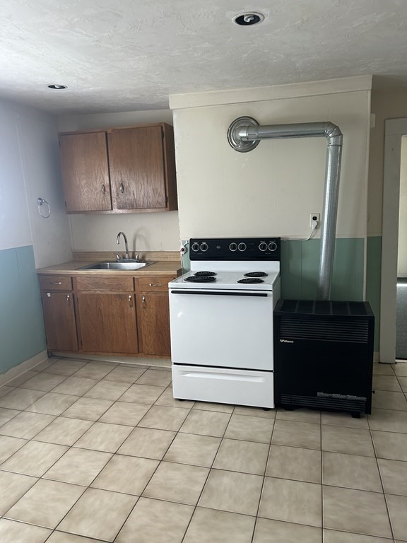 46 Tatman Street Worcester, MA 01607 - Photo 19 of 31 a kitchen with a stove top oven and cabinets