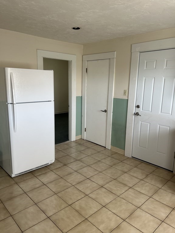 46 Tatman Street Worcester, MA 01607 - Photo 20 of 31 a view of a refrigerator in kitchen and white cabinets