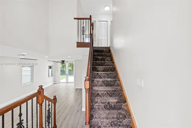 a view of a hallway with wooden floor and stairs
