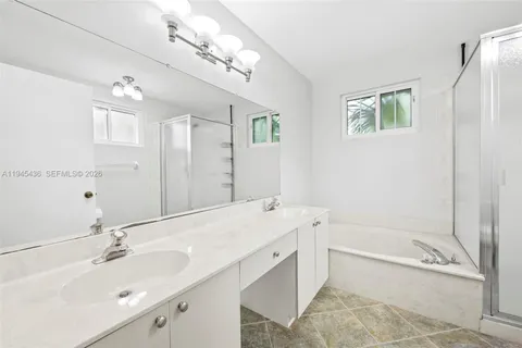 a spacious bathroom with a tub sink and mirror