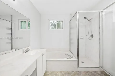 a bathroom with a granite countertop sink mirror and shower