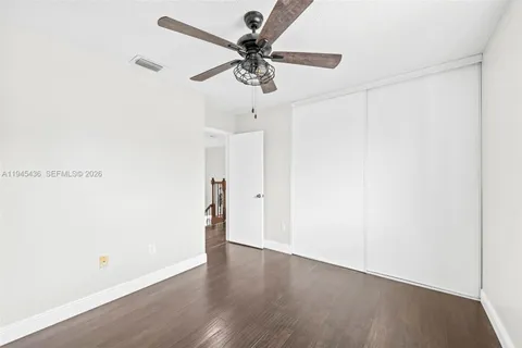 a view of room with hardwood floor and ceiling fan