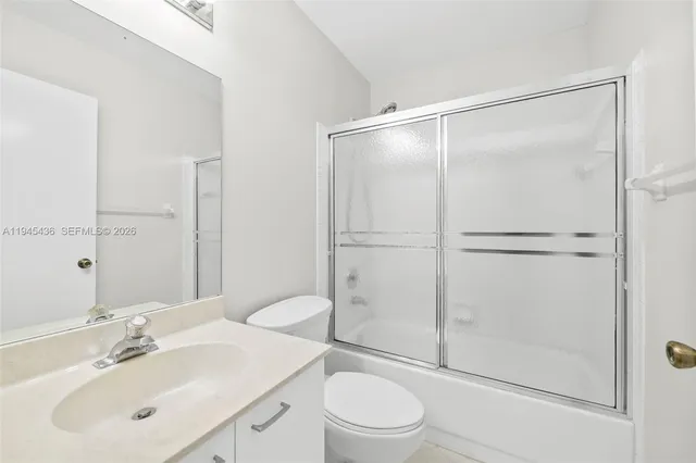a bathroom with a sink mirror vanity and toilet