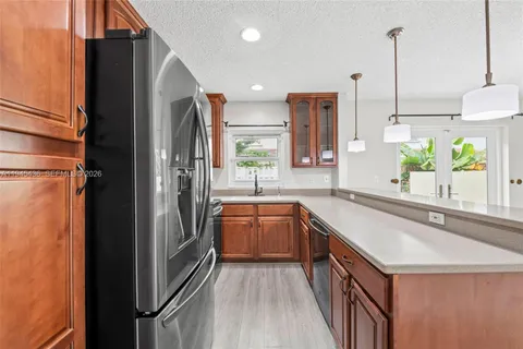 a kitchen with stainless steel appliances granite countertop a sink and a refrigerator