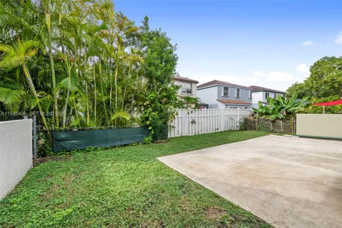 a view of a garden with plants and large trees