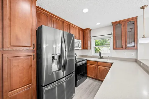 a kitchen with stainless steel appliances granite countertop a refrigerator and a sink