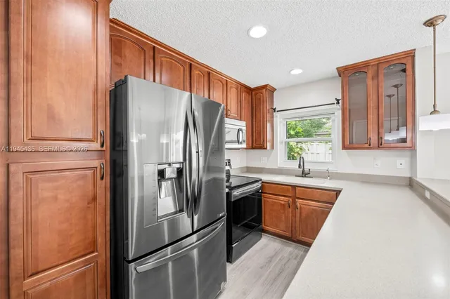 a kitchen with stainless steel appliances granite countertop a refrigerator and a sink