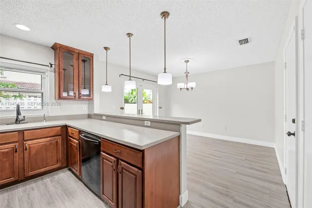 a kitchen with a sink a stove and wooden floor