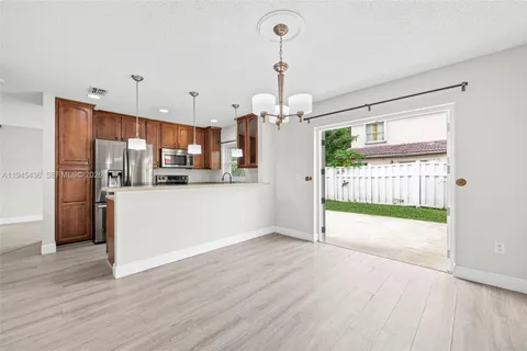 a view of a kitchen with a refrigerator wooden floor and a kitchen