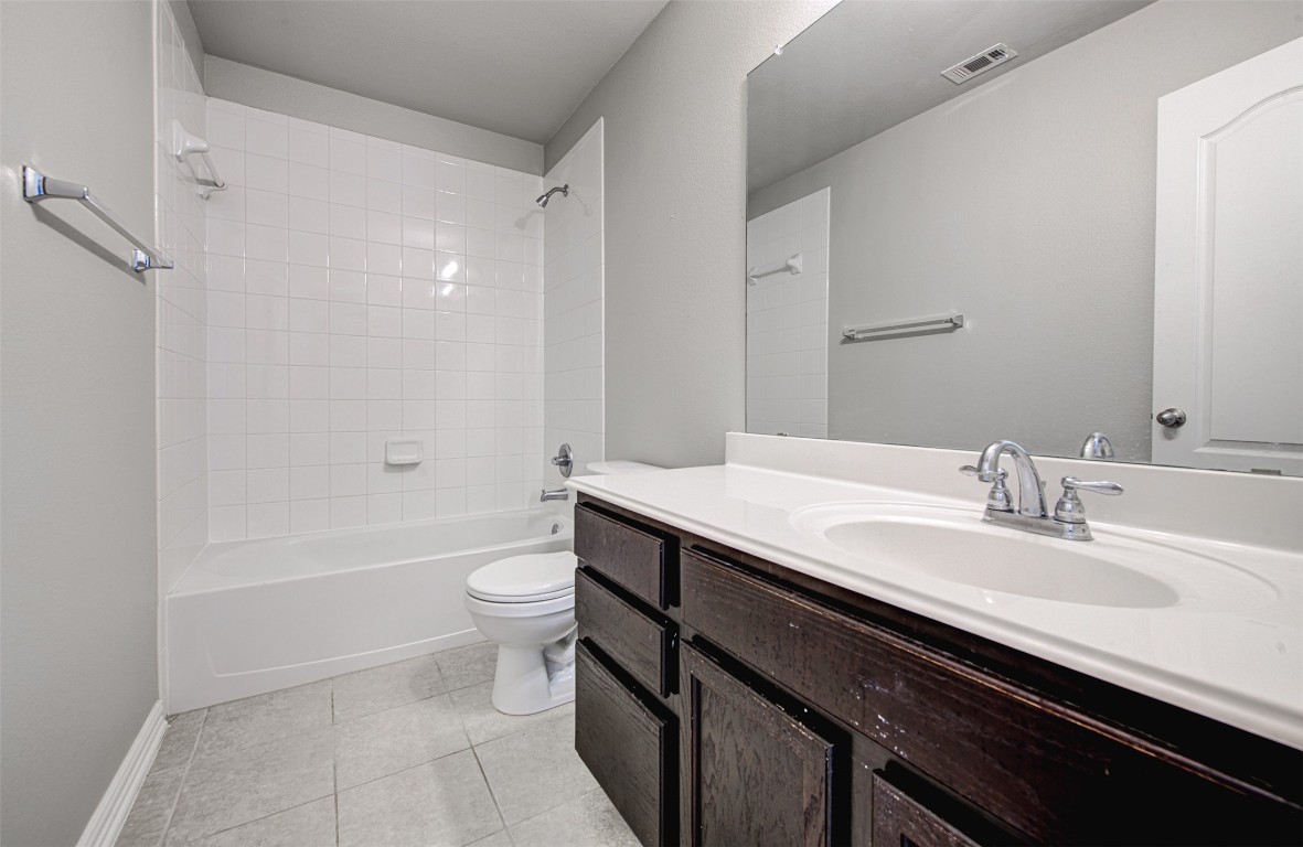 239 Pond View Pass Buda, TX 78610 - Photo 12 of 30 Bathroom with vanity, shower / bathtub combination, and light tile patterned floors