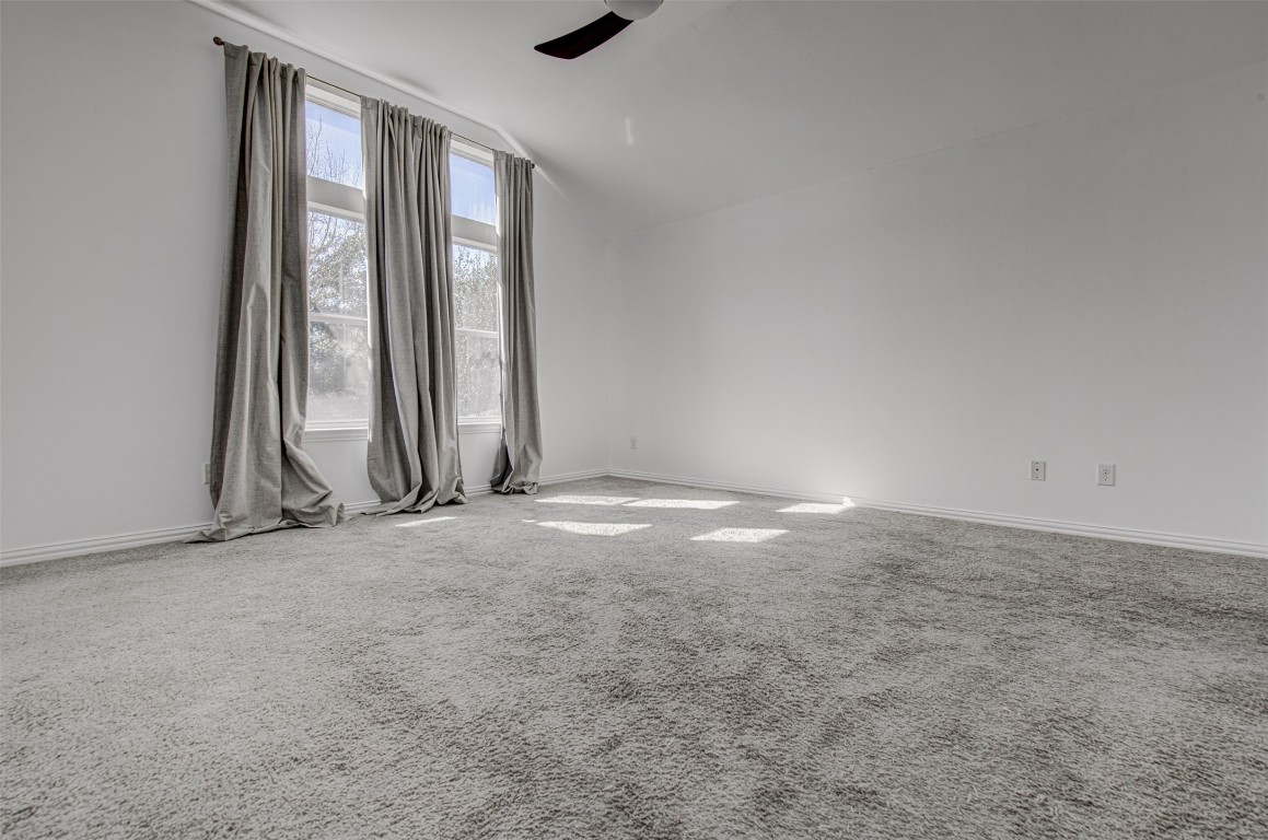 239 Pond View Pass Buda, TX 78610 - Photo 20 of 30 Carpeted spare room with vaulted ceiling and a ceiling fan