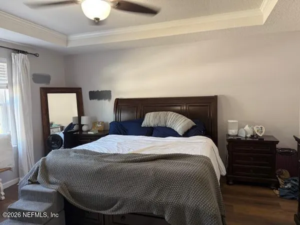 a bedroom with a bed and wooden floor